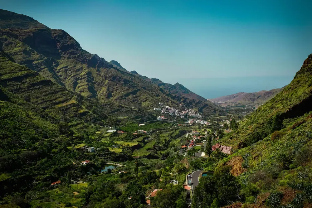 town in the green mountains in Gran Canaria with the sea in the distance