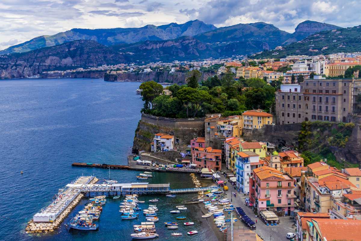 Puerto de Sorrento con barcas atracadas y acantilados al fondo, punto de partida ideal hacia Amalfi en ferry