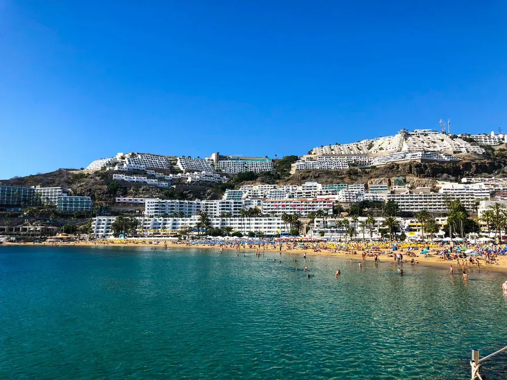 white buildings behind a busy beach in Gran Canaria