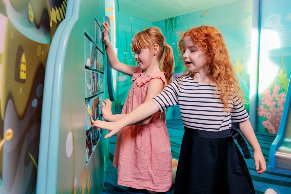 Niñas jugando en una zona infantil a bordo de un ferry, con espacio interactivo diseñado para el entretenimiento de los más pequeños.
